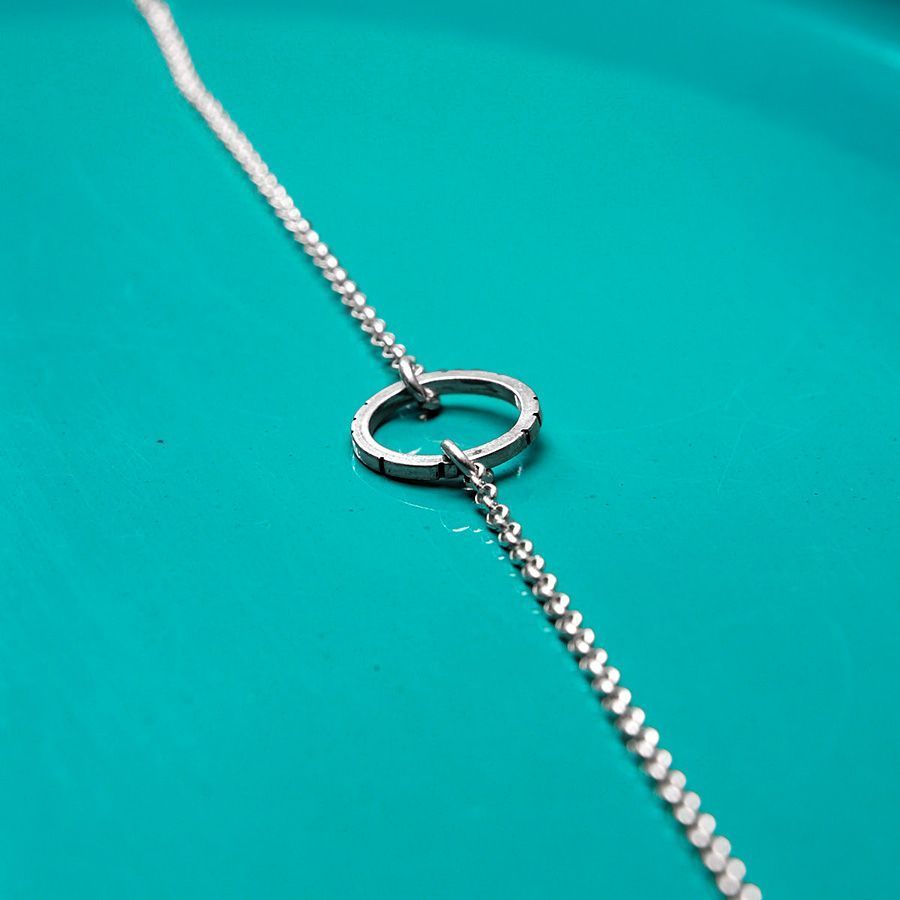 Pulsera en plata Square HOOP Pulsera en plata formada por un pequeño aro con sección cuadrada y una fina cadena de plata.